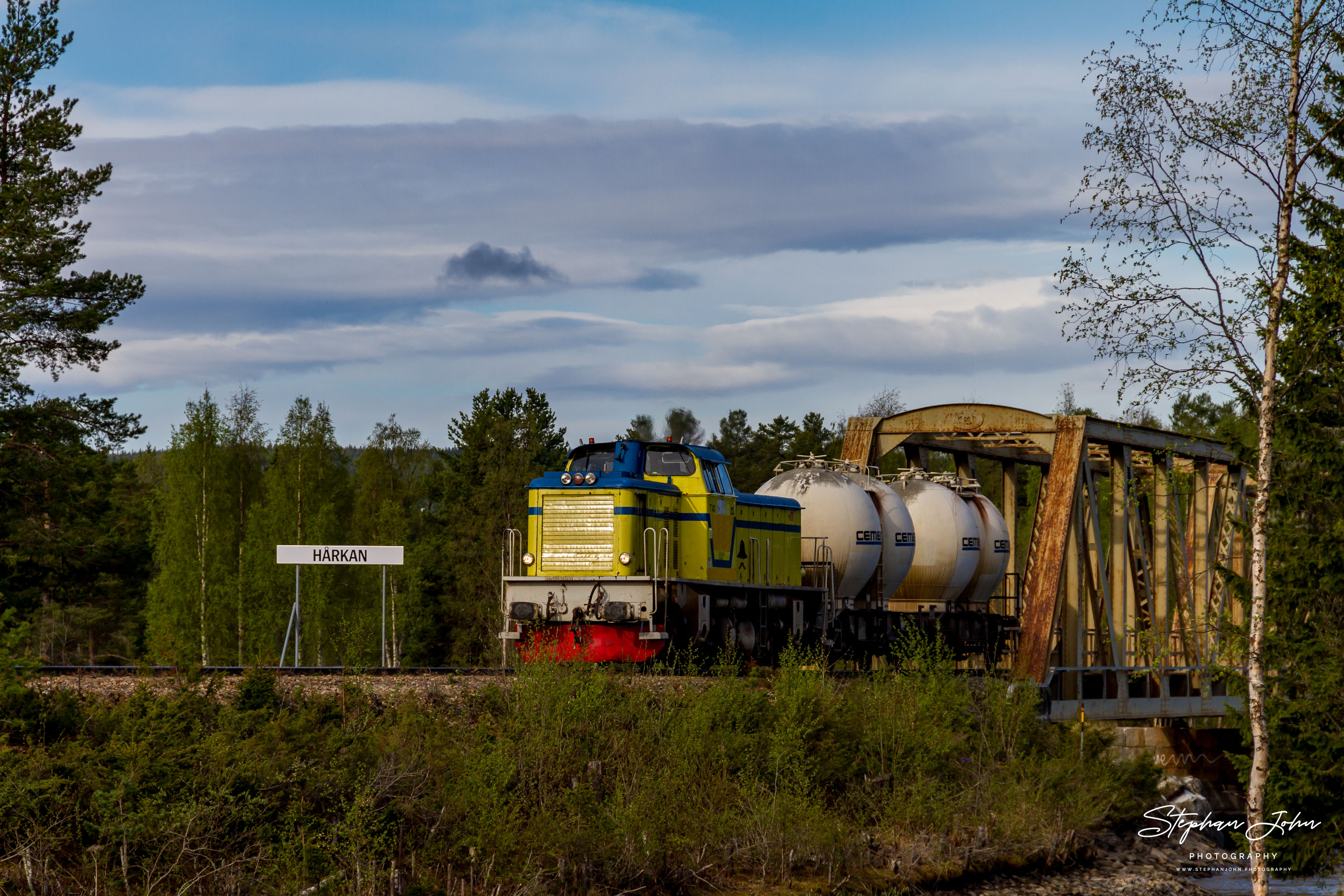 Ein kurzer Güterzug der Inlandsbanan in Schweden überquert den Fluß Hårkan bei Lit