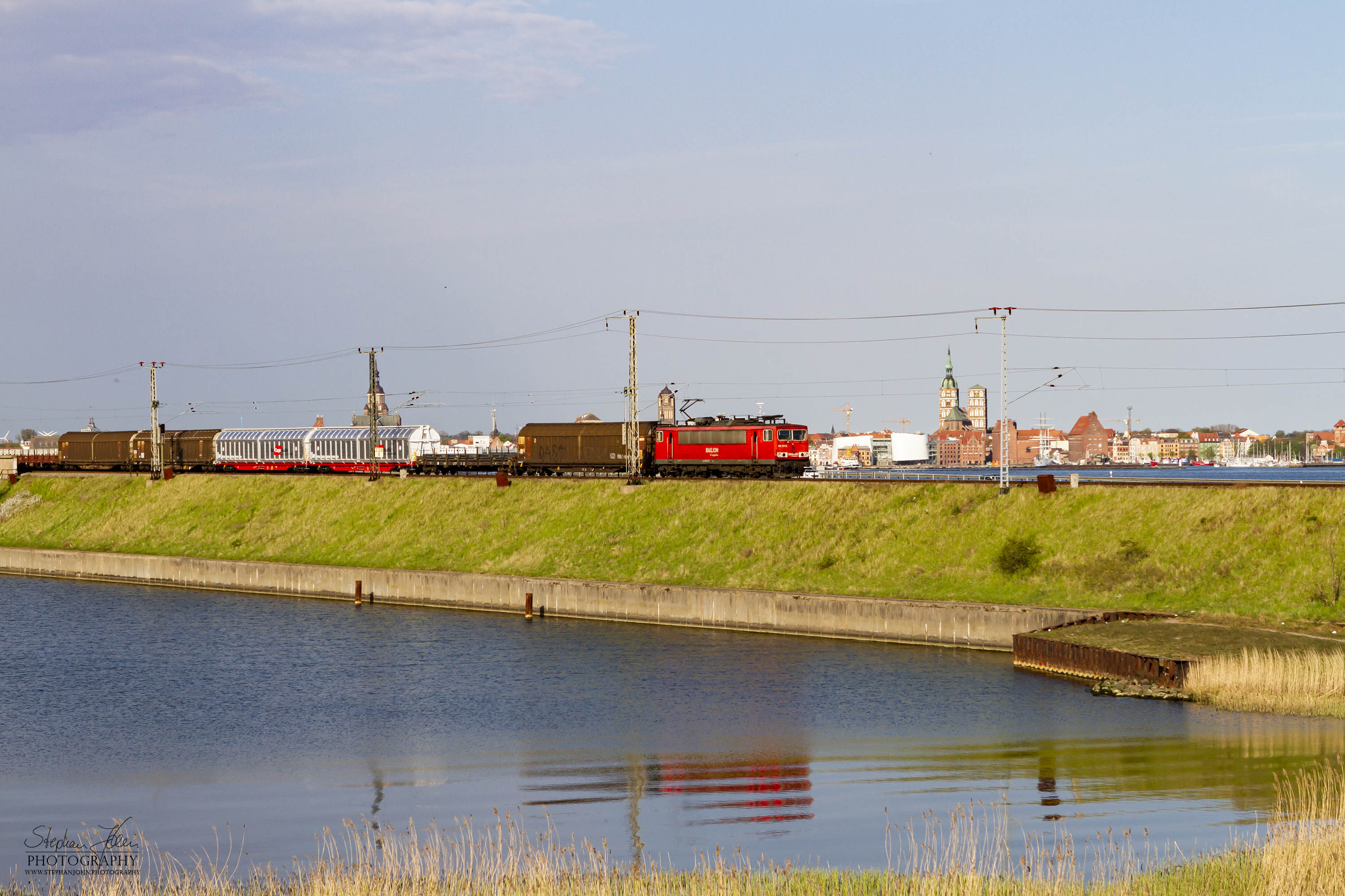 <p>Eine Lok der Baureihe 155 zieht einen Güterzug über den Rügendamm</p>