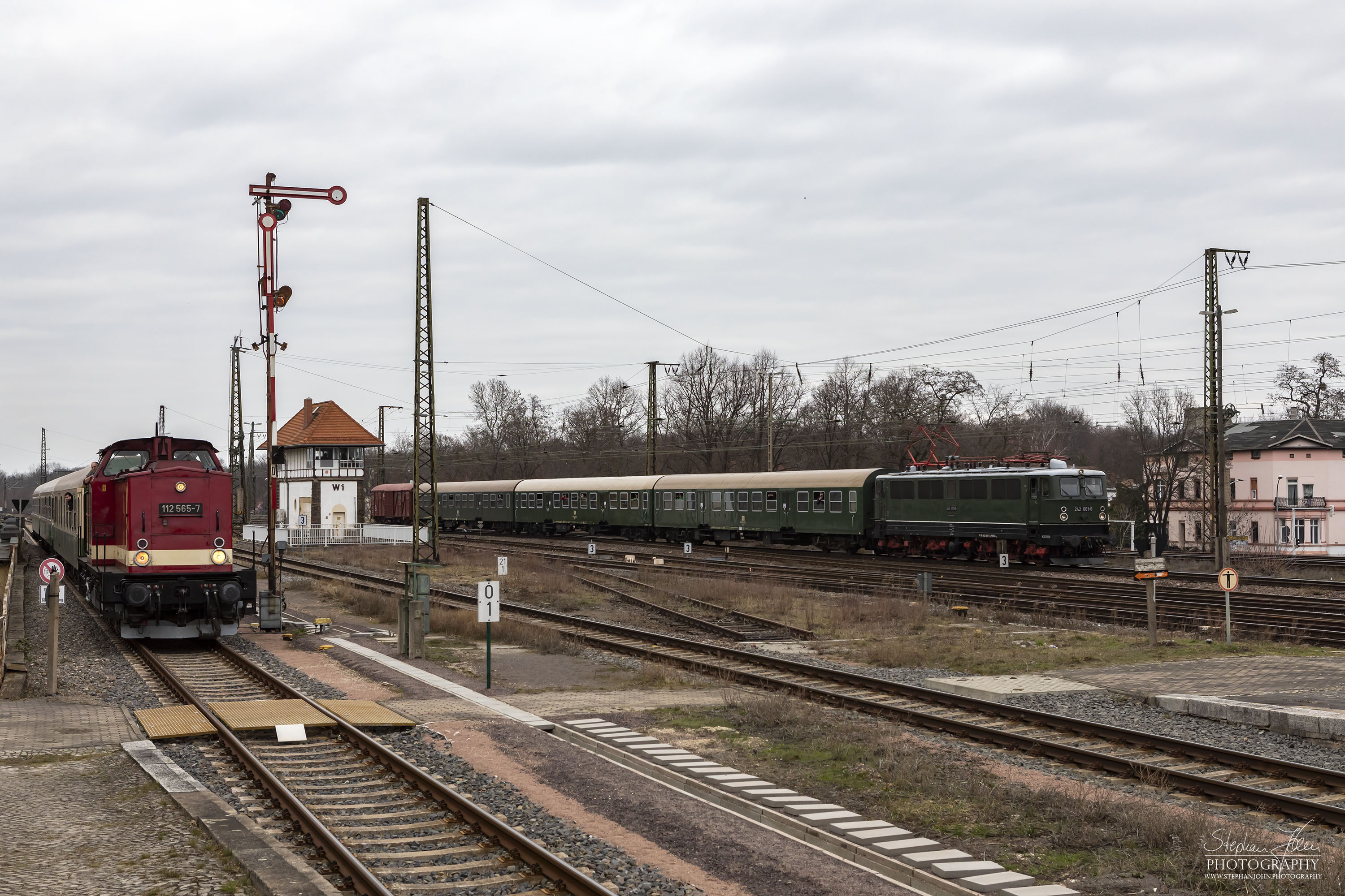 Zug 61439 mit Lok 112 565-7 von Dessau Hbf nach Bernburg und Zug 62189 mit Lok 242 001-6 von Calbe Ost nach Köthen erreichen gleichzeitig den Bahnhof Köthen.