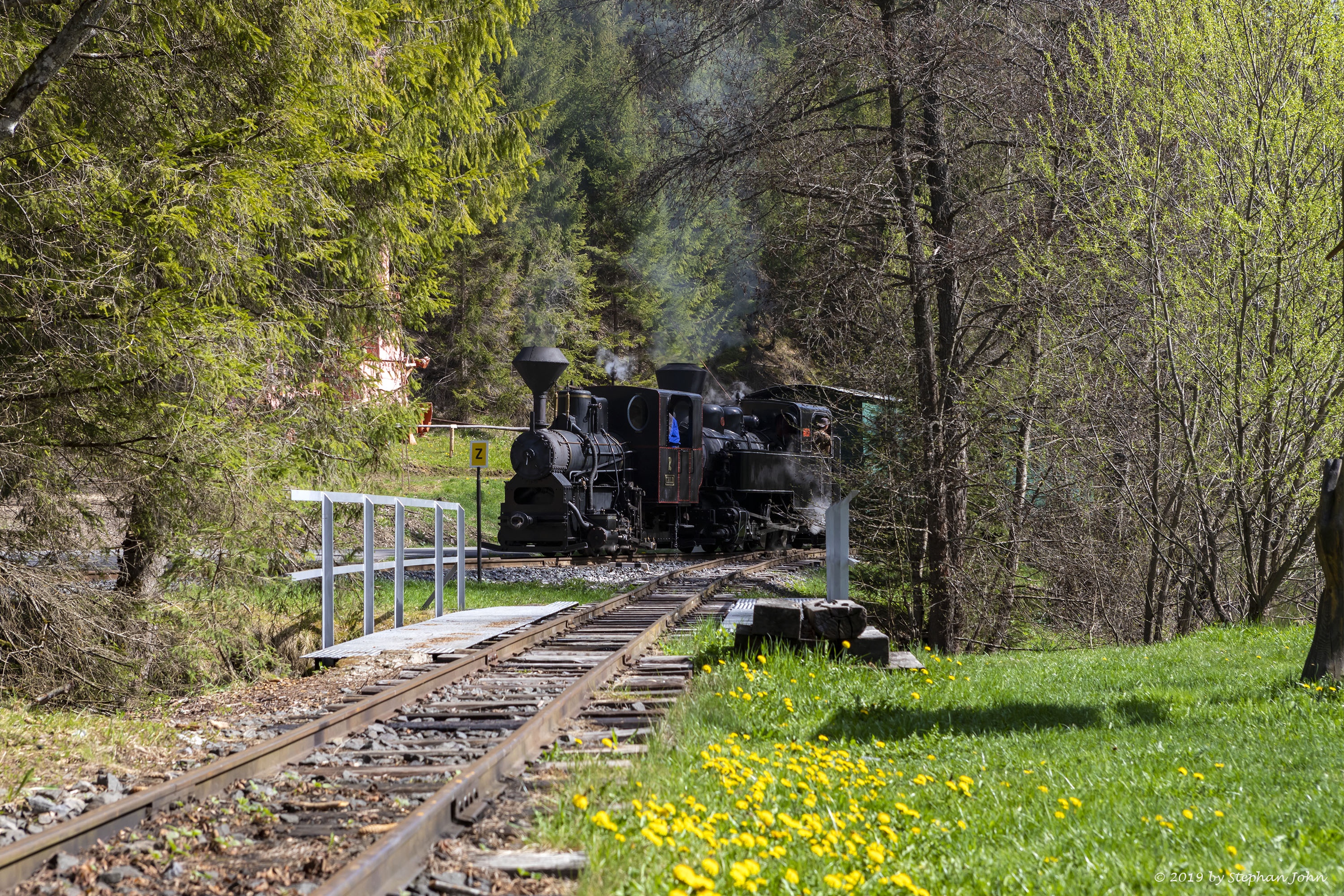 <p>Ein Zug der Waldbahn dampft mit zwei Lokomotiven die Strecke in Richtung Vydrovo entlang. Hier passiert der Zug einen Abzweig bei Korytárske</p>