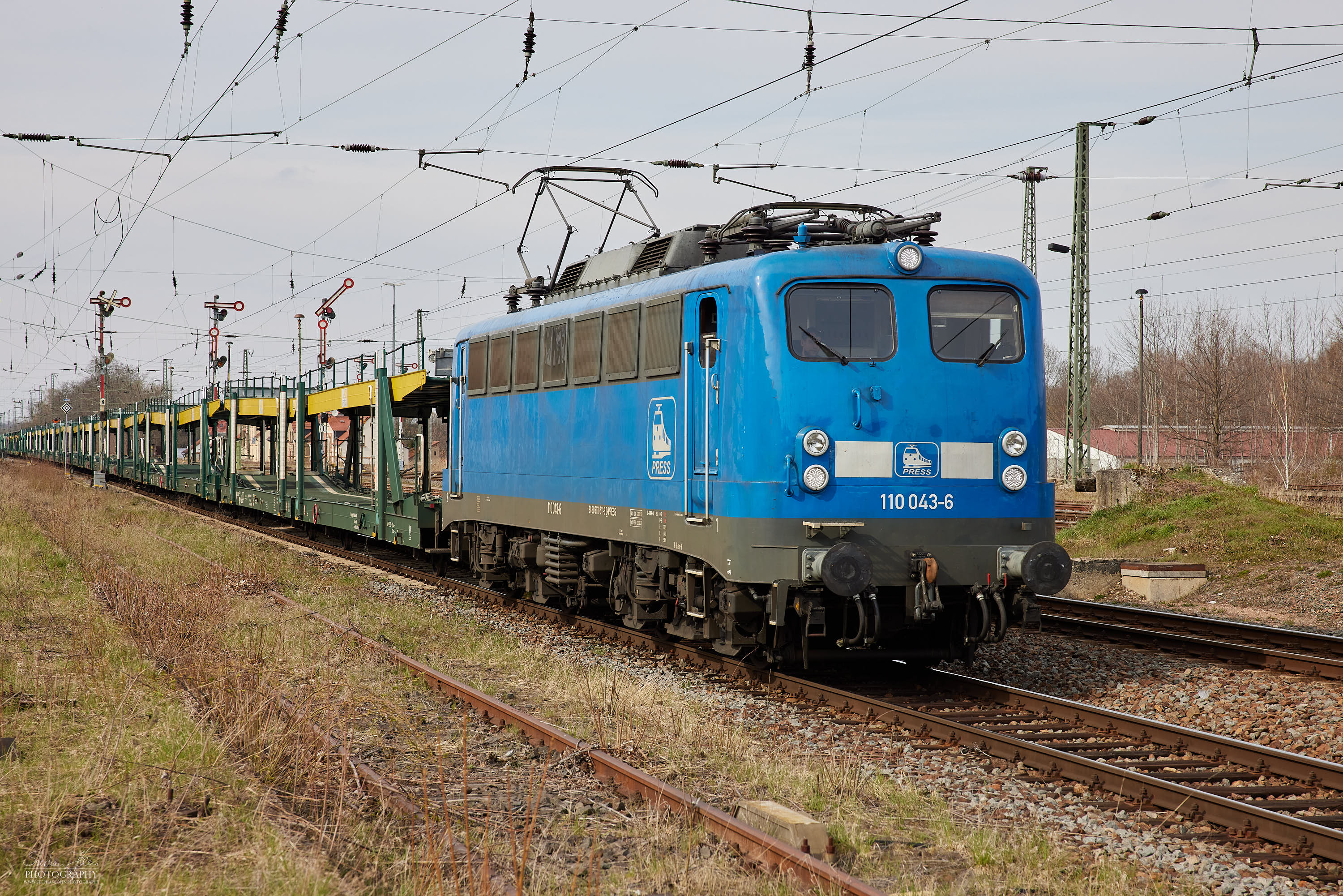 Ein Leergüterzug mit der Lok 110 043-6 fährt durch den Bahnhof Altenburg(Thür)
