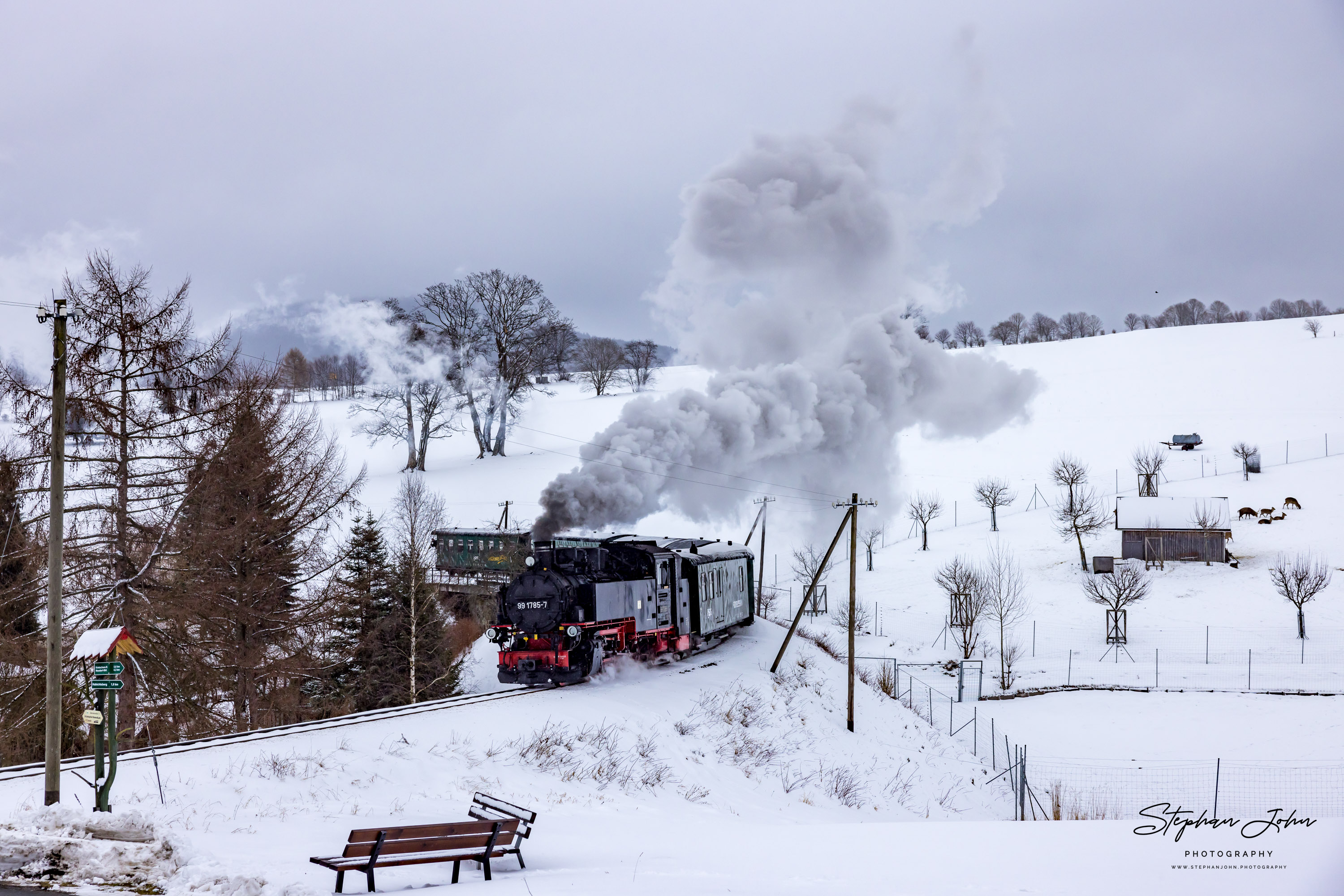 Bei leichtem Schneefall verlässt der von der Lok 99 1785-7 gezogene Zug P 1005 die Ortslage Cranzahl und überquert gleich den BÜ Hofweg