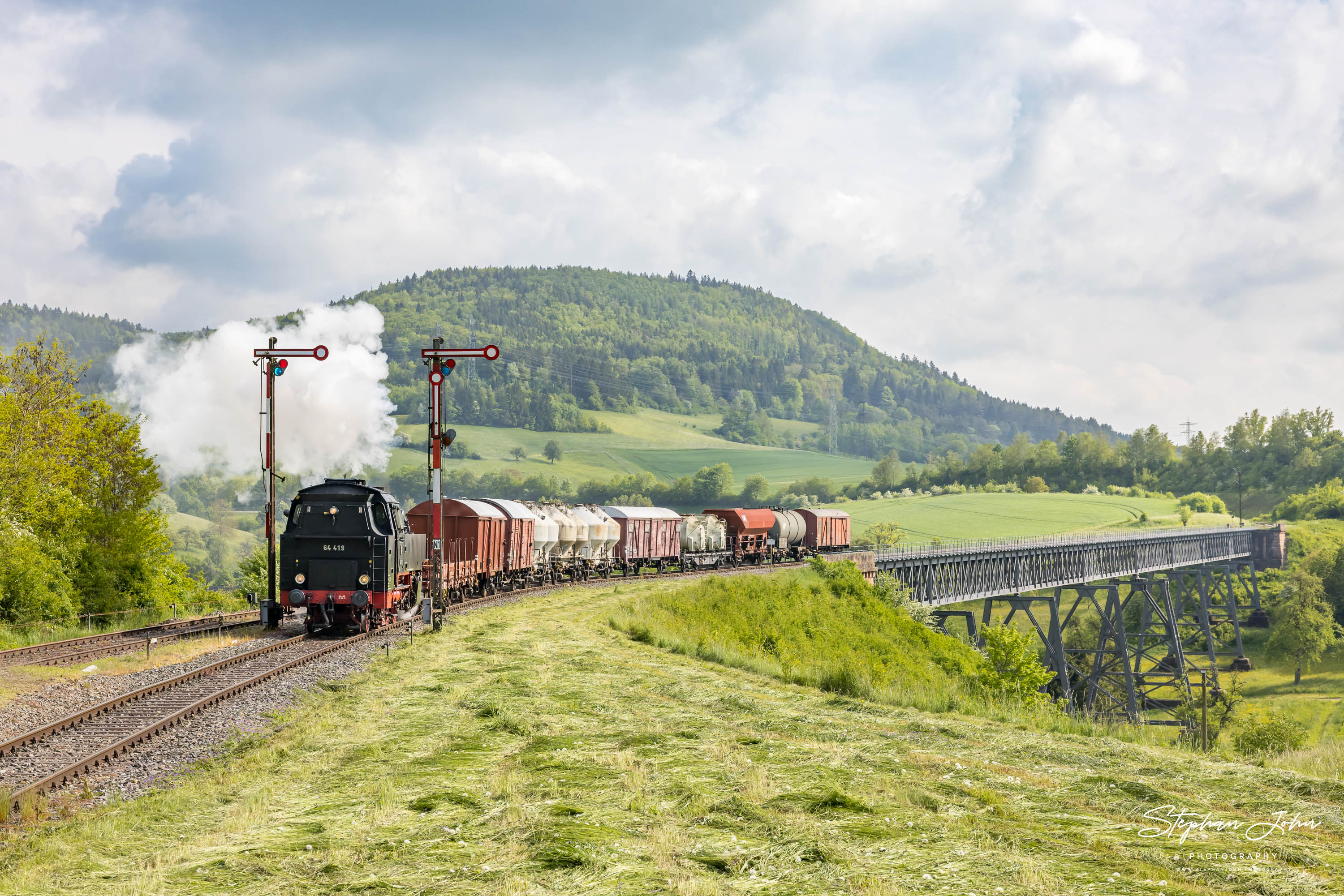 Lok 64 419 mit einem Güterzug nach Fützen erreicht den Bahnhof Epfenhofen