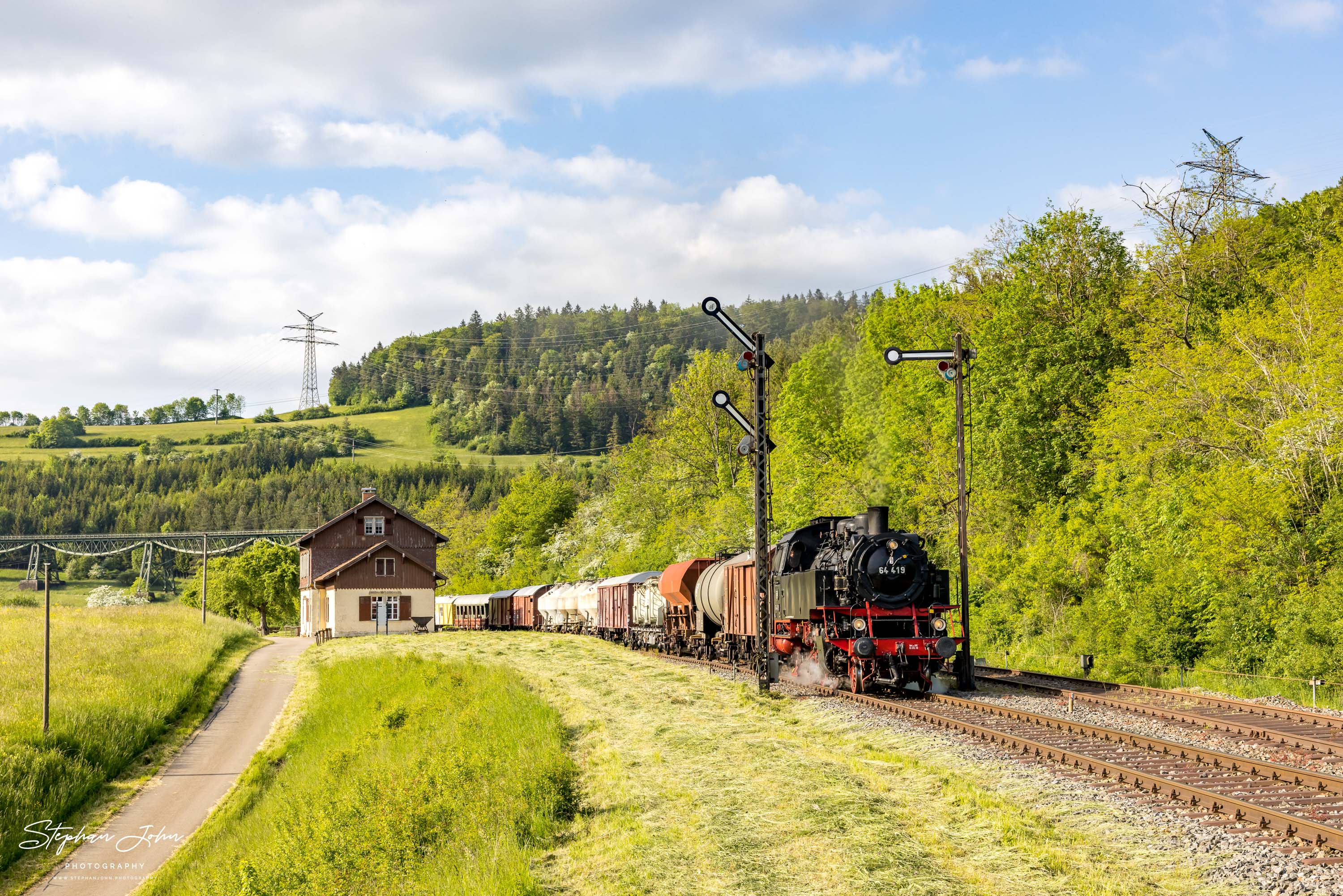 Lok 64 419 mit einem Güterzug nach Blumberg fährt aus dem Bahnhof Epfenhofen aus