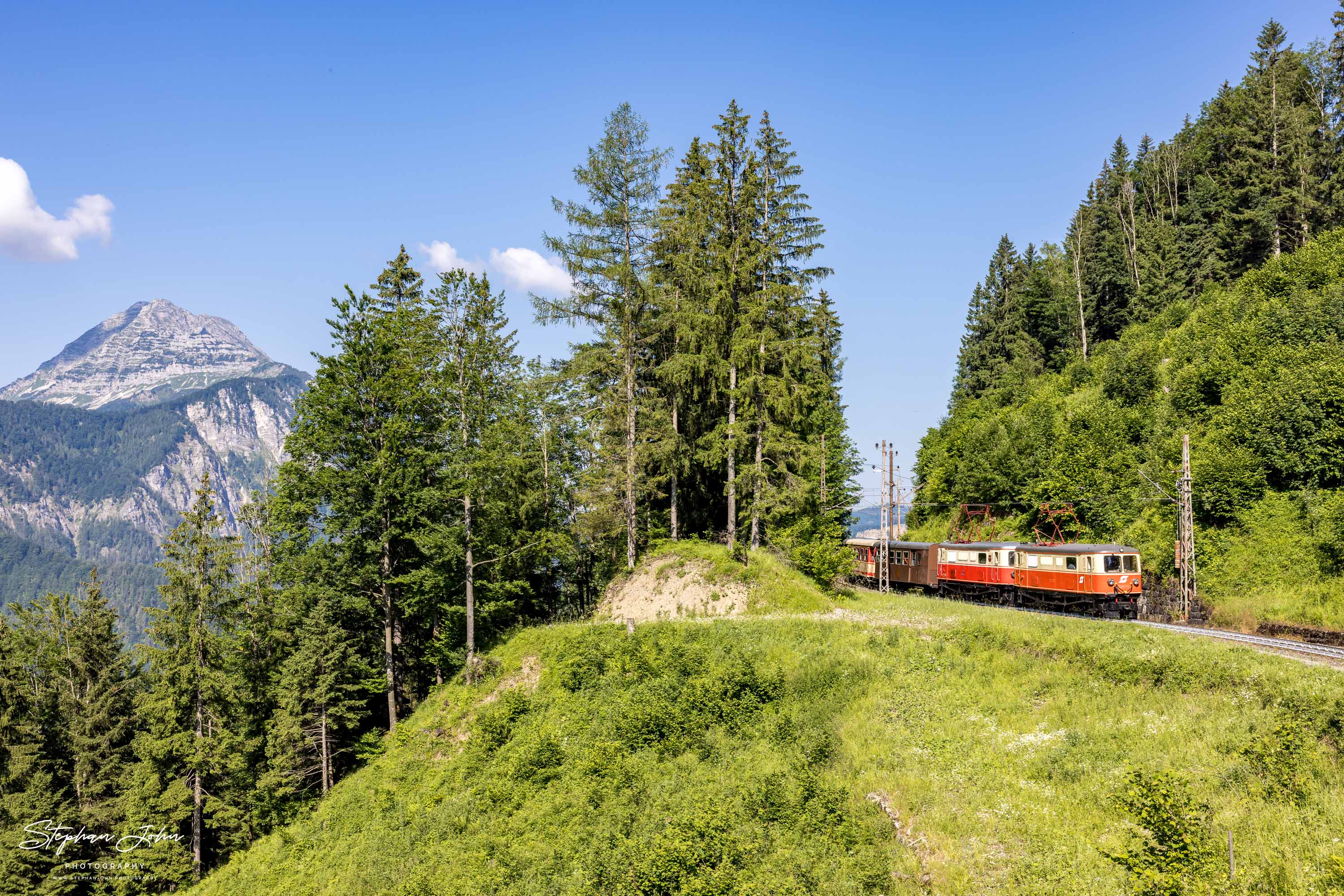 Zug 80963 mit Lok 1099.11 und 1099.14 nach Mariazell auf der Strecke kurz nach Gösing. Im Hintergrund ist der Berg Ötscher zu sehen.