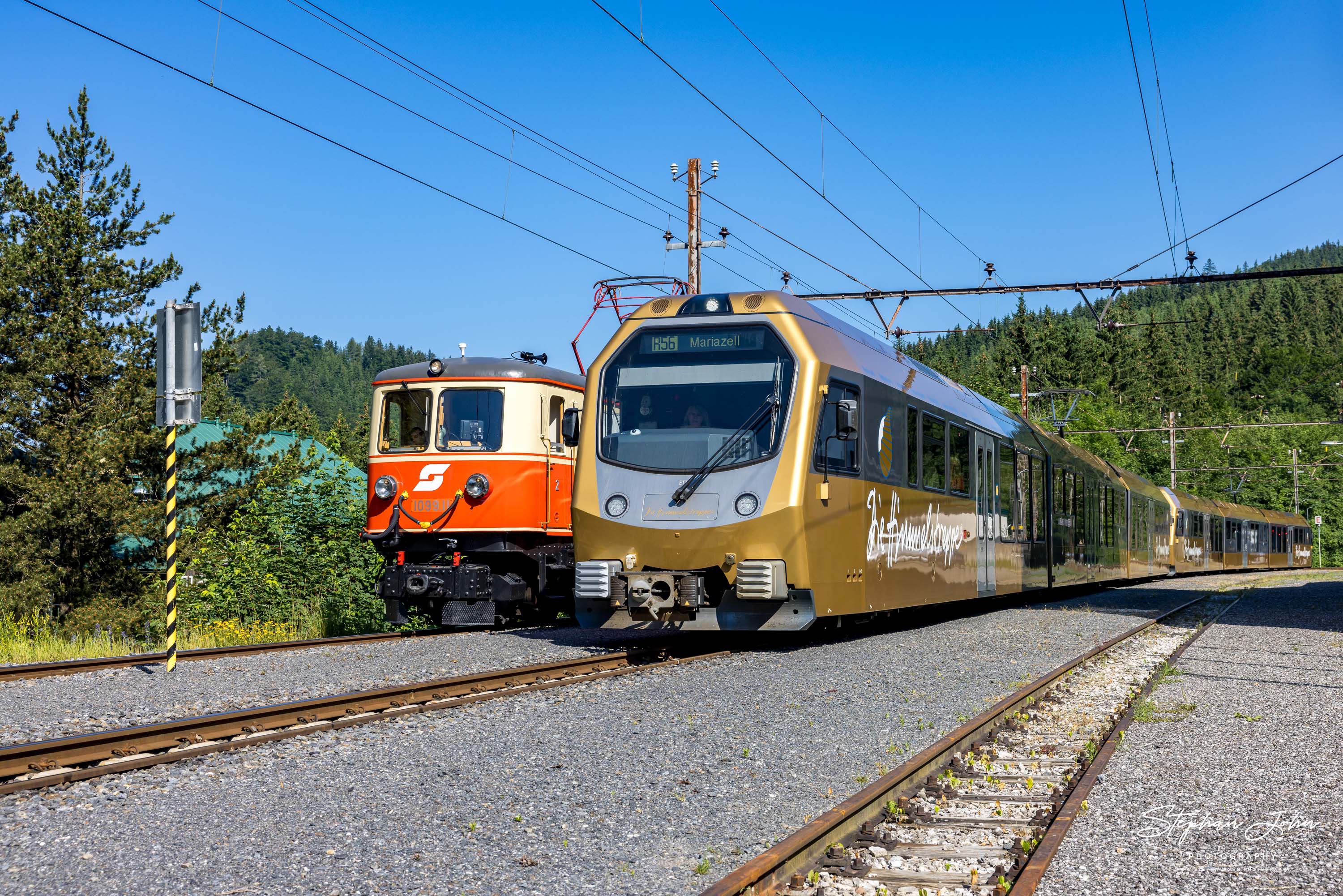 Zug 80963 mit Lok 1099.11 und 1099.14 nach Mariazell im Bahnhof Gösing. Die Himmelstreppe 6805 überholt.