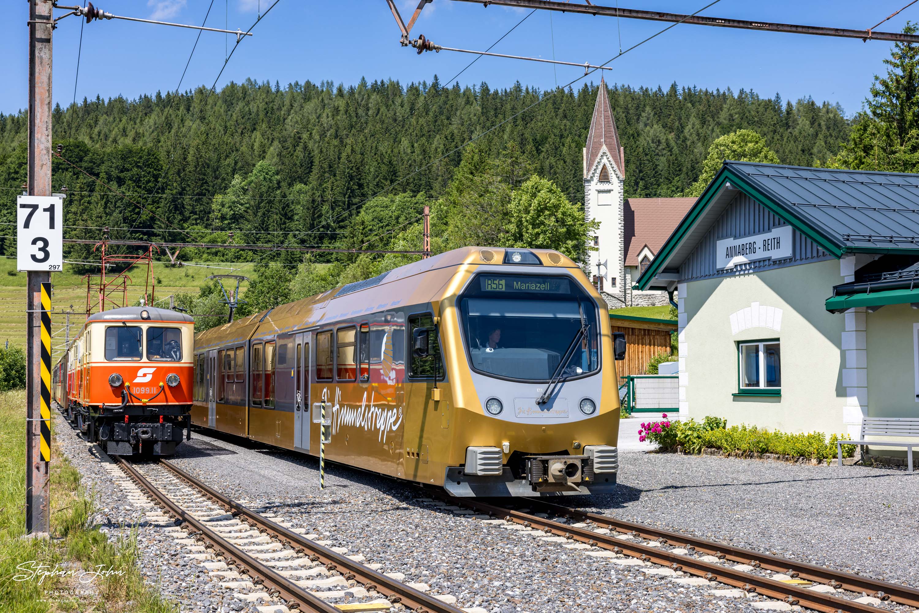 Zug 80965 mit Lok 1099.11 und 1099.14 steht in Annaberg-Reith und wird von der Himmelstreppe 6811 nach Mariazell überholt