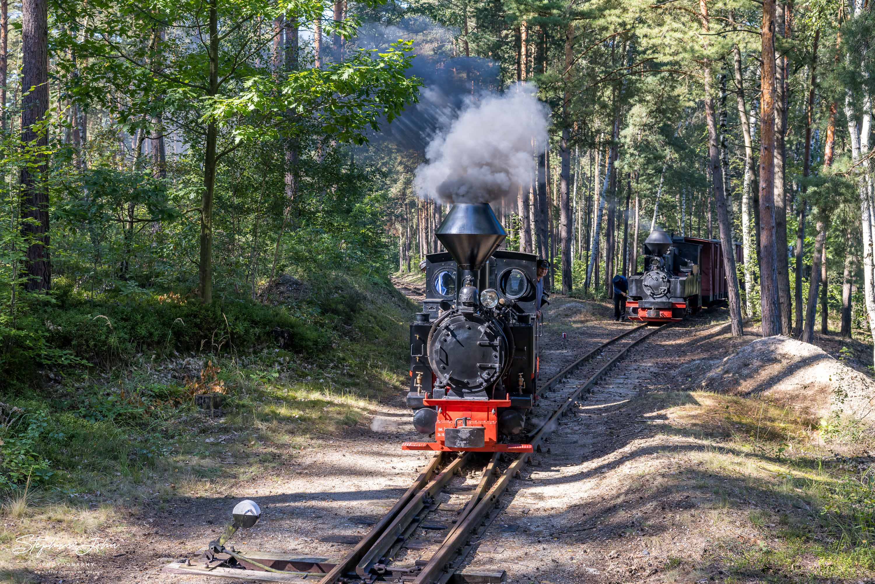 Lok 99 3301 erreicht mit einem Lorenzug den Abzweig Adolf, während Lok 99 3315-1 mit einem Zug im Abzweig wartet