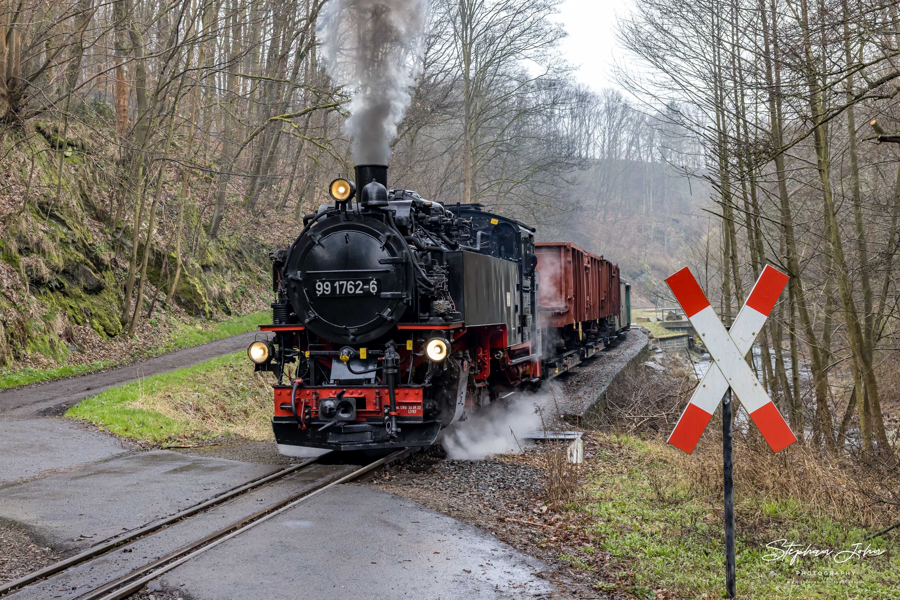 Lok 99 1762-6 dampft mit P 5100 durch das Tal der Roten Weißeritz und passiert am Haltepunkt Spechtritz den Bahnübergang