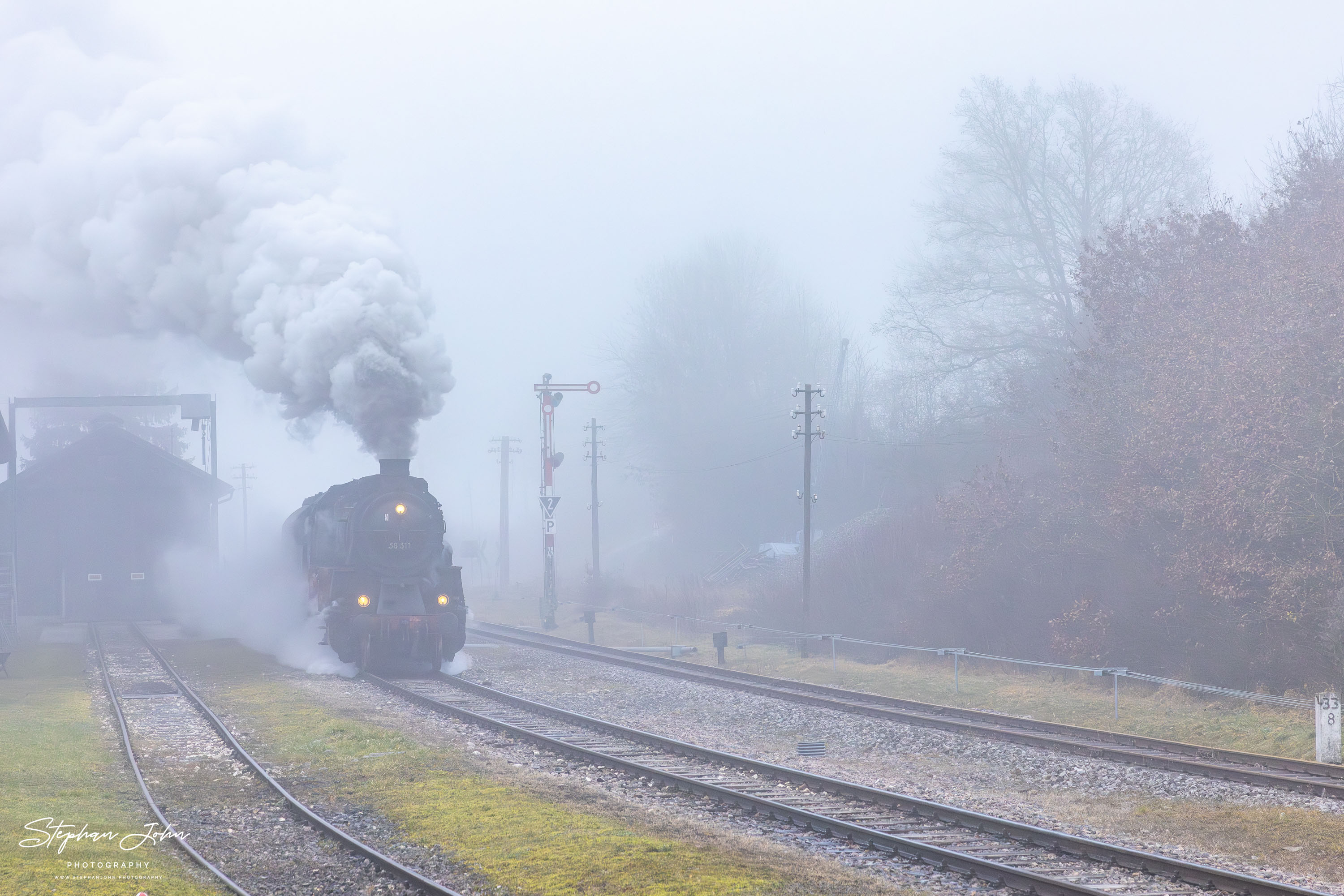 Im dichten Nebel fährt Lok 58 311 mit Zug 88237 in Fützen ein
