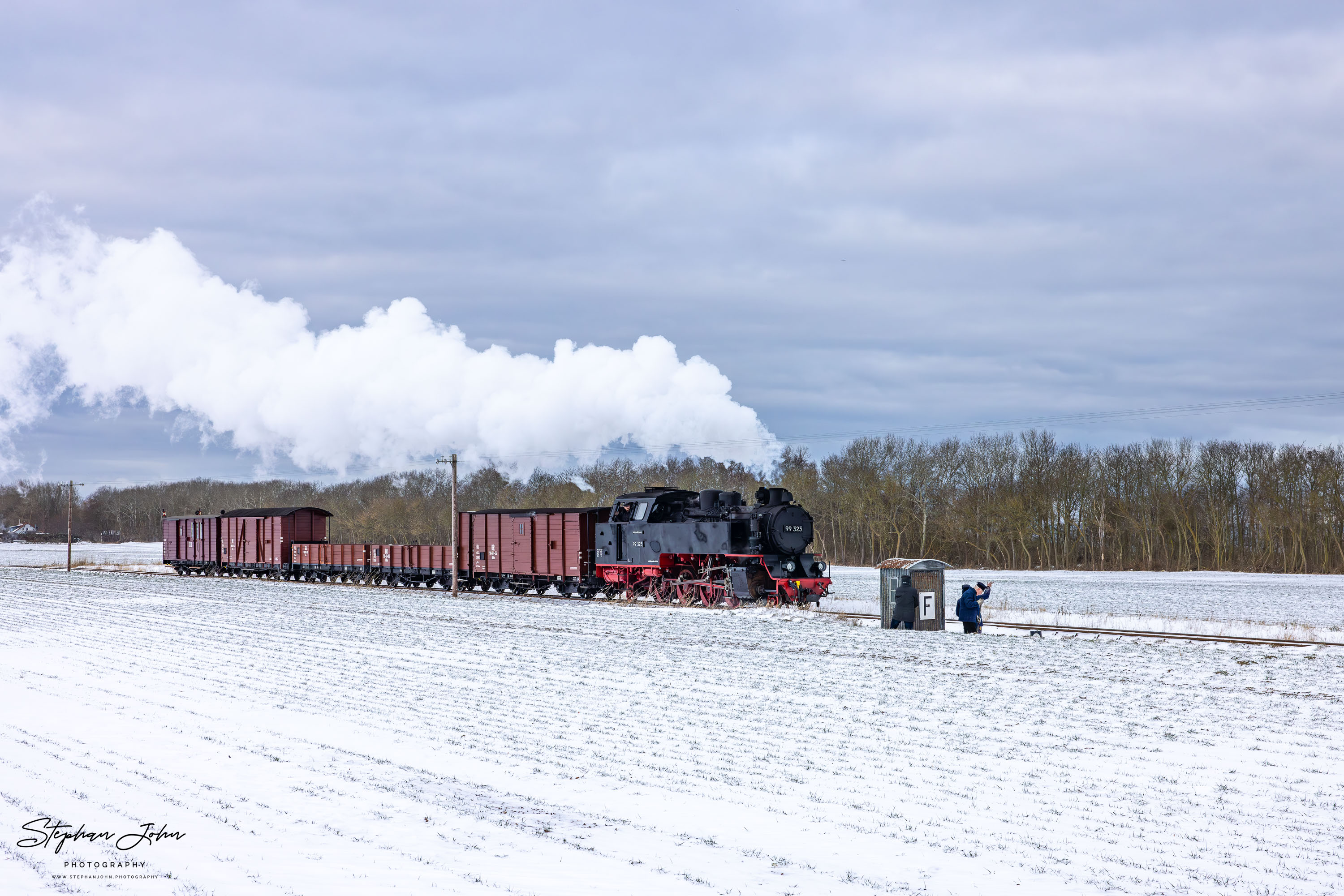 Lok 99 323 mit einem Güterzug auf dem Weg von Kühlungsborn West nach Heiligendamm passiert einen Fernsprechposten