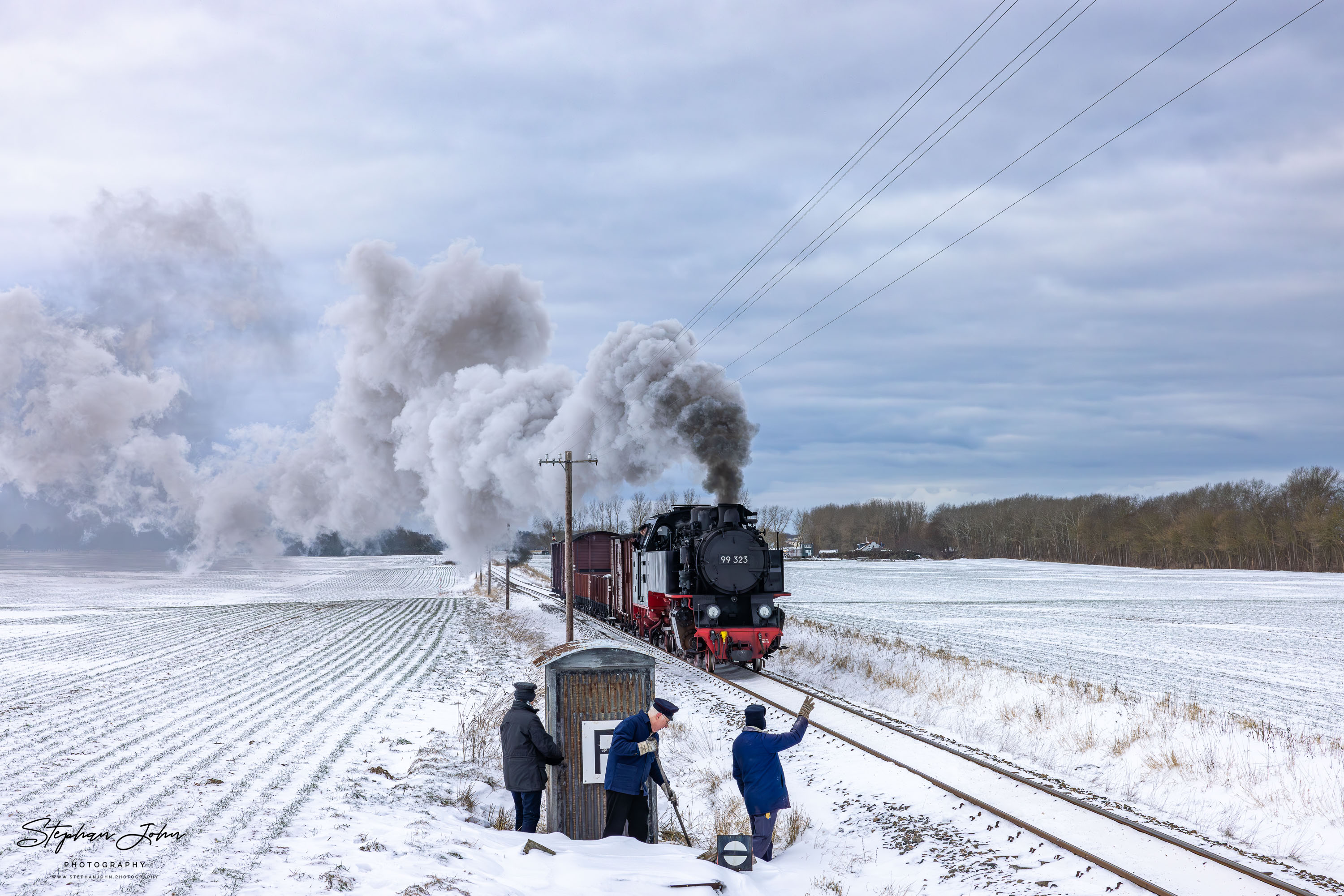 Lok 99 323 mit einem Güterzug auf dem Weg von Kühlungsborn West nach Heiligendamm passiert einen Fernsprechposten